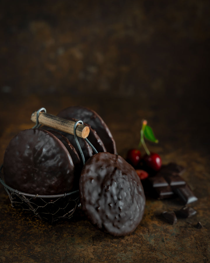 Schoko-Kirsch-Lebkuchen in einem Drahtkörbchen, daneben Kirschen und Schokolade